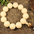 White jade bodhi root meditation bracelet top view on linen showing natural grain and round bead arrangement