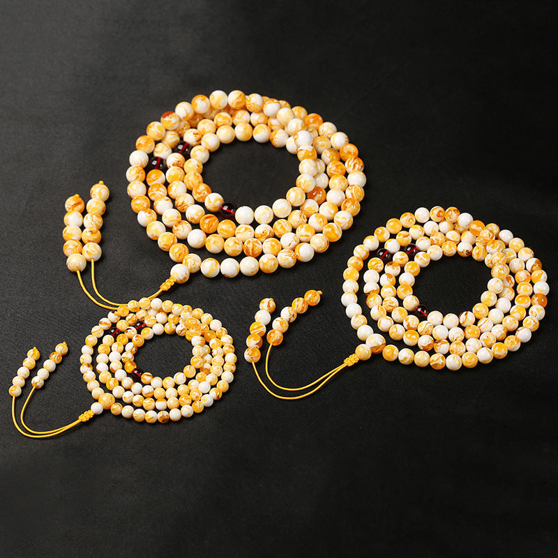 White flower beeswax 108 bead mala in three sizes 6mm 8mm 10mm comparison flat lay black background Taoist KaiGuang meditation mala red agate spacer beads