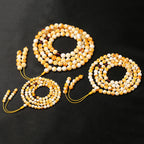 White flower beeswax 108 bead mala in three sizes 6mm 8mm 10mm comparison flat lay black background Taoist KaiGuang meditation mala red agate spacer beads