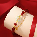 Women love attraction bracelet on white display stand showing red agate beads white jade peace clasp gold auspicious cloud connectors and Fu charm against red silk background

