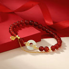 Women love attraction bracelet with deep red agate beads white jade peace clasp gold auspicious cloud setting and Fu charm on red silk background Taoist KaiGuang jewelry